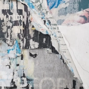 Peeling painted wall with torn layers exposing older surfaces beneath