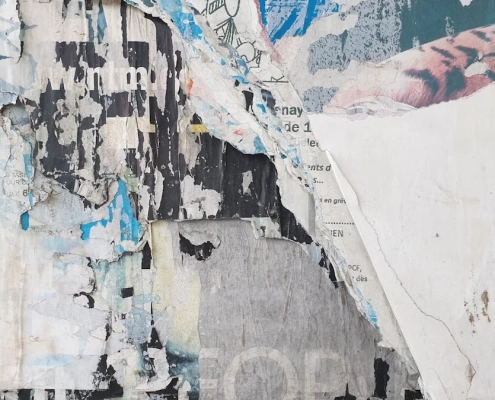 Peeling painted wall with torn layers exposing older surfaces beneath