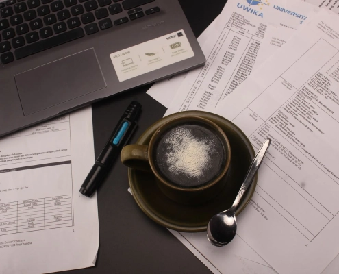 Copywriter's desk with a laptop, coffee and printed drafts