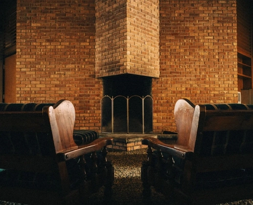 Two armchairs facing each other in front of a brick fireplace