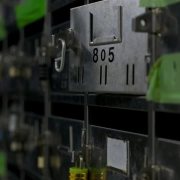 A row of identical numbered metal mailboxes, one of them open — a visual metaphor for choosing one name from a shortlist of interchangeable candidates