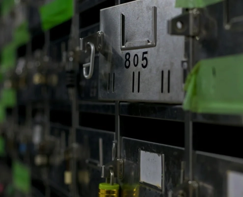 A row of identical numbered metal mailboxes, one of them open — a visual metaphor for choosing one name from a shortlist of interchangeable candidates
