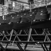 Rows of empty black chairs in tiered seating, shot in black and white